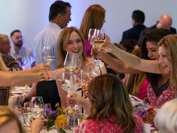 Group of women clinging their glasses together in celebration