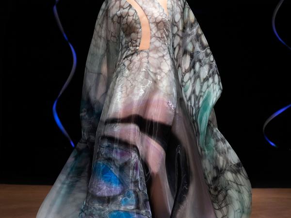 Woman modeling a flowing gown resembling the ocean floor