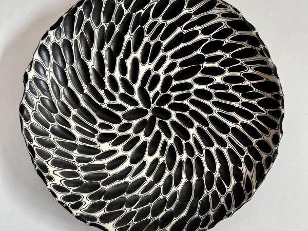 Circular plate with a design of black and white swirls
