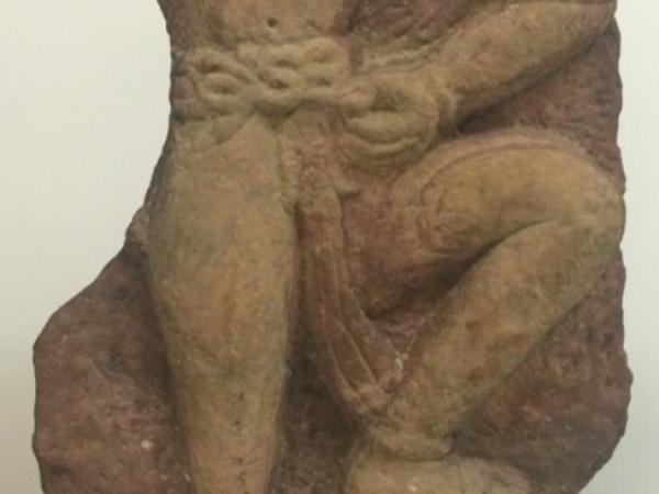 Stone sculpture of a headless male figure