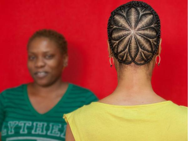 The back of a woman's head showing an elaborate flower-shaped haircut pattern