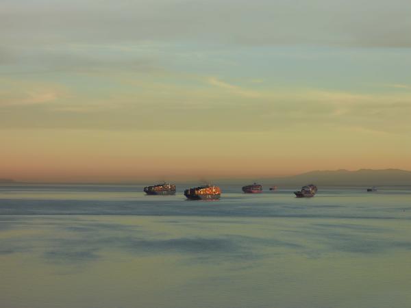Cargo ships on the sea during a very early morning sunrise
