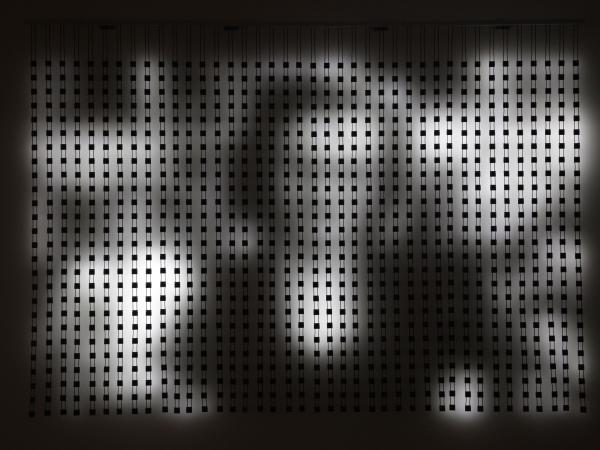 Peg board artwork with white and black shadows resembling a billowy woman figure