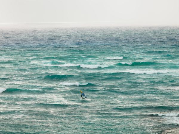Man wing surfing on bright blue ocean waters