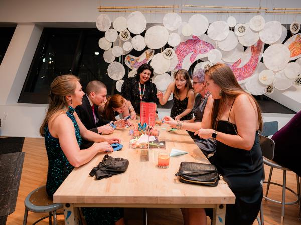 Group of well-dressed men and women making arts and crafts