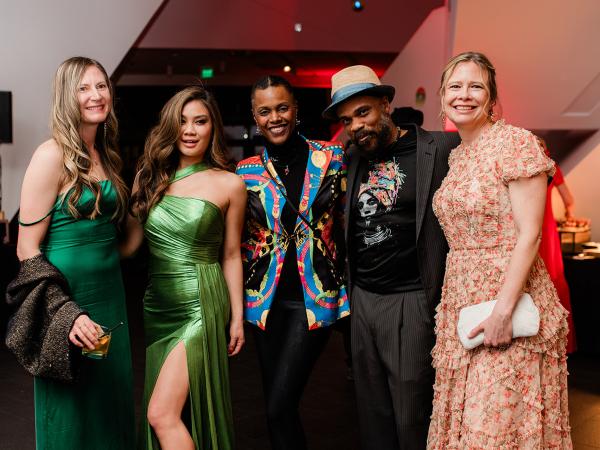 Group of well-dressed partygoing men and women posing for the camera 
