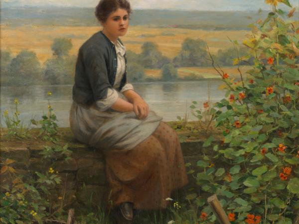 A woman sitting on a log by the lake, contemplating