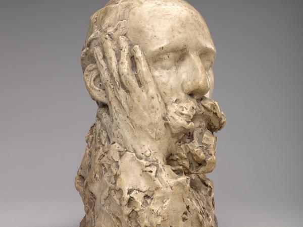 Bust of a man with a hand touching the side of his face