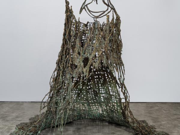 Abstract bronze installation resembling a maiden wearing a large flowing gown