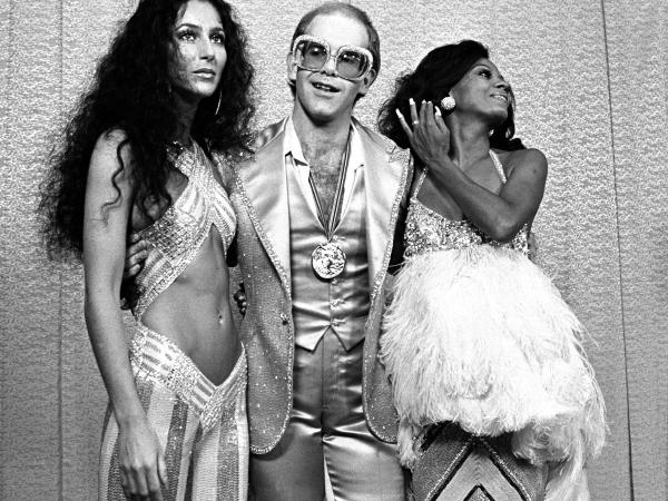 Black and white photograph of Cher, Elton John, and Diana Ross