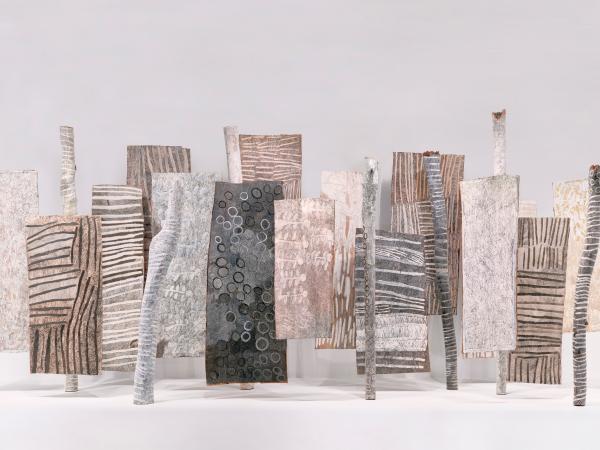 Row of upright earth pigments made to resemble tree bark and tree stumps