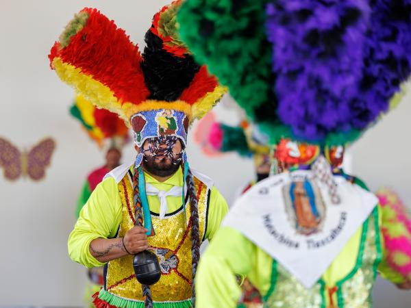 Two young boys dressed in colorful costumes performing at Dia del Nino