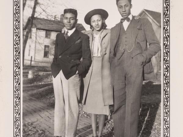 Two African American men and an African American woman posing in formal wear