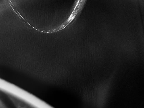 Extreme close-up of a man wearing a t-shirt with a snippet of a face visibile