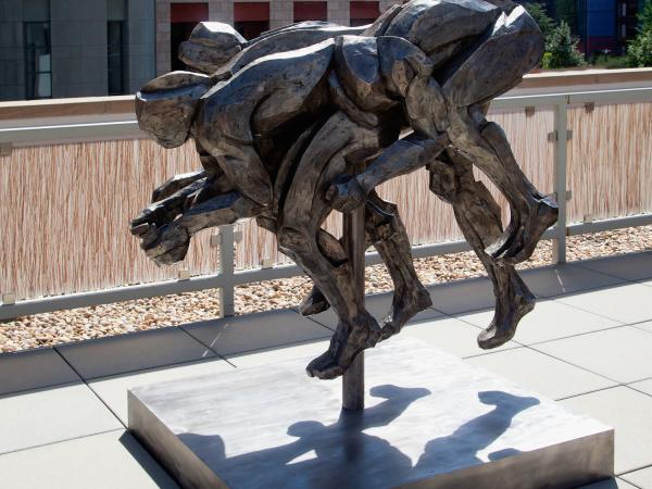 Bronze statue of intertwining figures resembling a four-legged animal