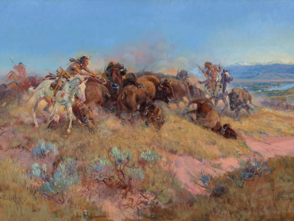 Group of Native Americans circling around a buffalo