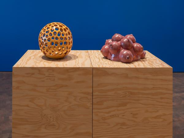Two sculptures resting on wooden podiums
