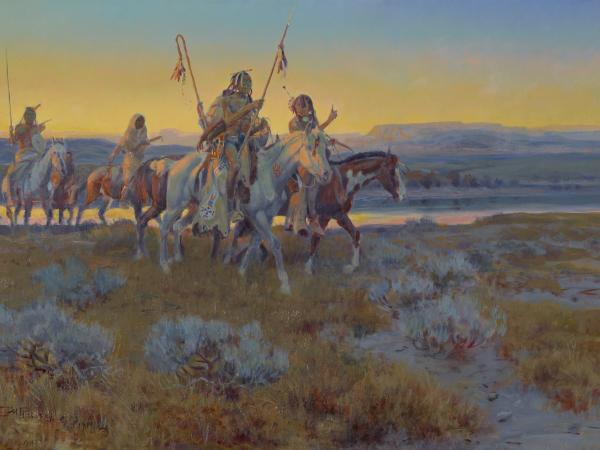 Group of Native Americans on horseback, riding at sunset