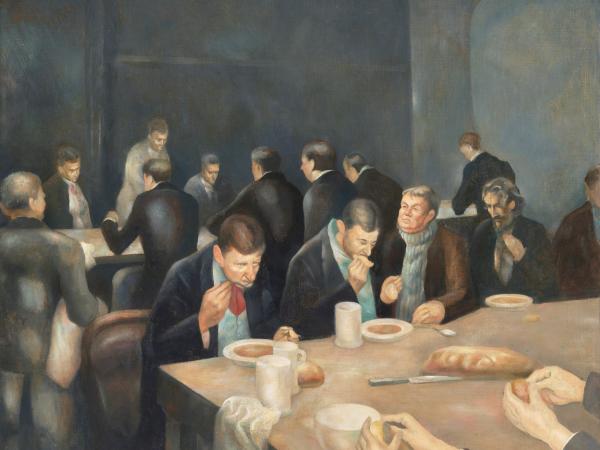 Group of men sitting at tables eating bread and soup
