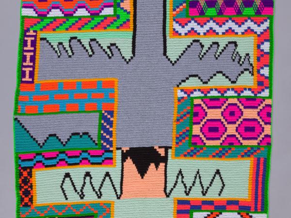 Colorful patterned wool textile with a large gray bird in the center with its wings outstretched