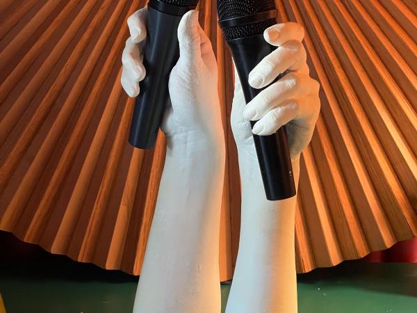 Two mannequin hands holding microphones in each hand
