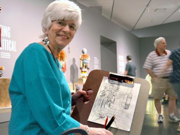 a woman holding up a drawing in the exhibition Jeffrey Gibson: Like a Hammer