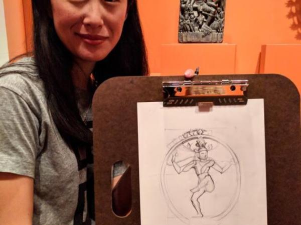 a woman holding a drawing of Shiva she drew in the Linking Asia exhibition