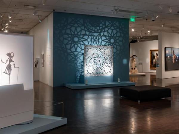 Installation view of The Light Show exhibition showing artworks that give off shadows and several paintings