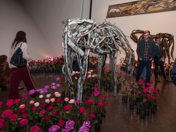 vases of roses surrounding horse sculptures in art gallery at Untitled Final Friday