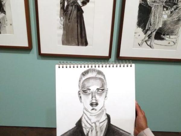 a drop in drawing student holding a drawing in the Jim Howard exhibition