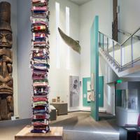 Dozens of colorful blankets stacked on top of each other to make a very tall tower