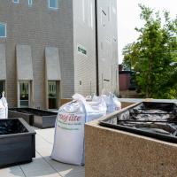 View of the in-progress garden with large bags of soil next to empty planters