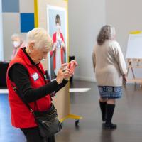 An older woman taking photos inside the exhibition