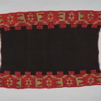 A black textile with red and gold graphic designs on the top and bottom
