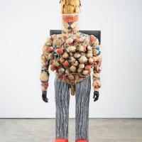 Large human-like sculpture of a man made out of TV screens