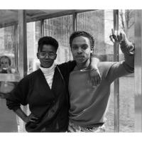 A young black couple embracing at a bus stop station