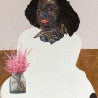 Black woman in white sitting and posing at a table
