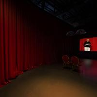 Projection screen in a red-curtained room with two chairs