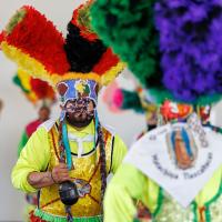 Two young boys dressed in colorful costumes performing at Dia del Nino