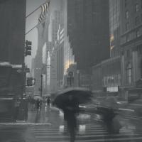 Man walking the New York City streets under an umbrella on a rainy day