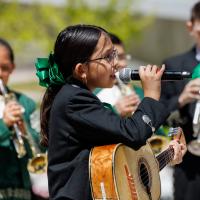Young girl performing guitar and singing at Dia del Nino