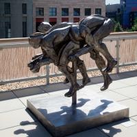 Bronze statue of intertwining figures resembling a four-legged animal
