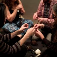 Visitors crocheting chains out of different fiber with artist Viviane Le Courtois inside the Global Thinking Pod