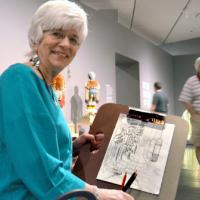 a woman holding up a drawing in the exhibition Jeffrey Gibson: Like a Hammer