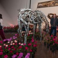 vases of roses surrounding horse sculptures in art gallery at Untitled Final Friday