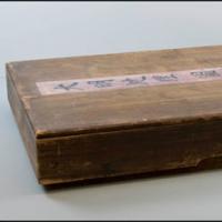 two photos of the cedar box that stored the ming dynasty map; one view of the top of the box and one view from the side