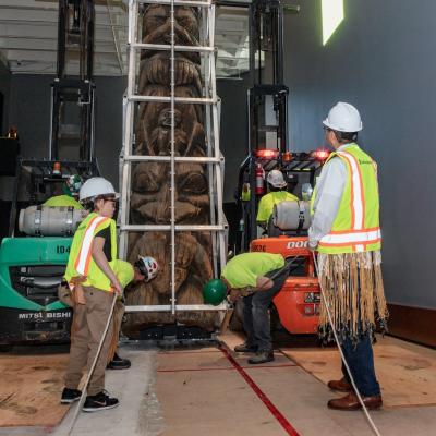 Tristen Washington (left) and Lee Wallace (right) with members of Demiurge LLC escorting Land Otter Pole into place.