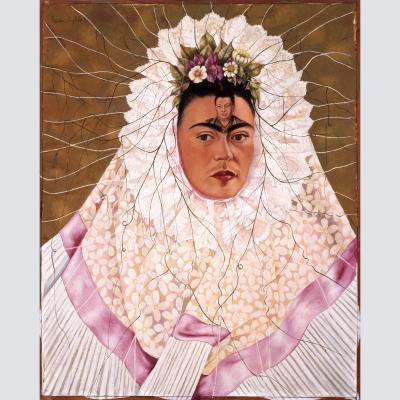 Retrato de Kahlo lleva puesto un tocado de color claro que le rodea la cara. Por sobre sus cejas hay un pequeño retrato de Rivera y flores en la línea de comienza su cabello.