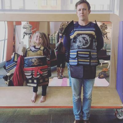 Kid posing next to Samurai suit of armor
