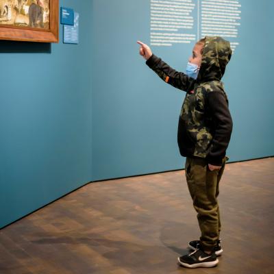 Young boy pointing at a painting